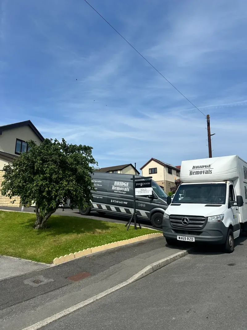 Bridge Removals van out on the road between house removal jobs, houses close behind.