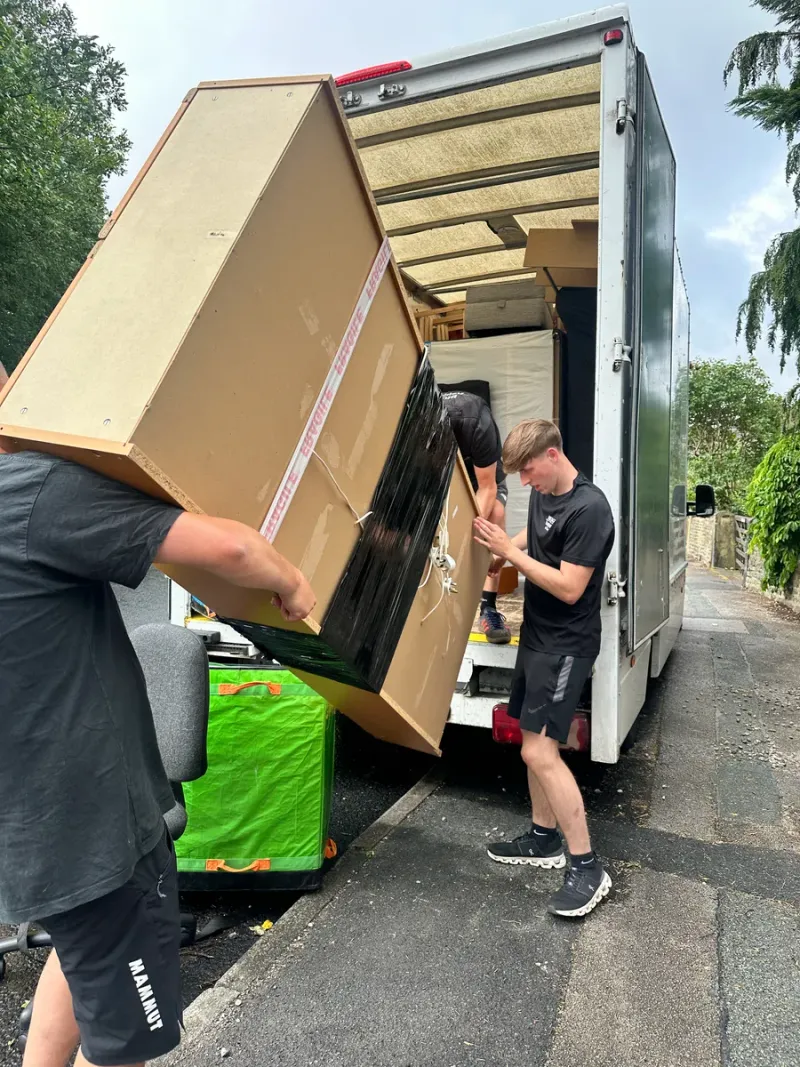 Bridge Removals crew loading a boxed item onto the van tail lift.