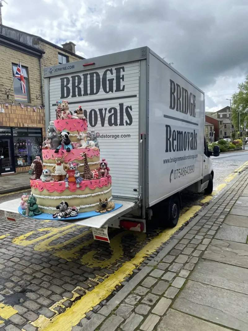 Giant teddy bear birthday cake displayed on a Bridge Removals tail lift in Rawtenstall, during a house removals job.