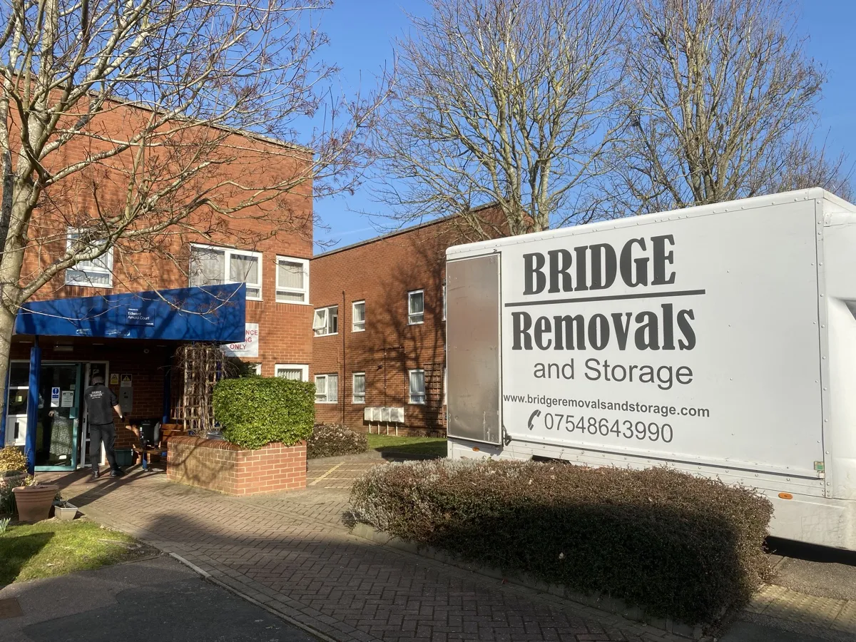Long-Distance Removals at a Bedford Apartment Block Bridge Removals van outside a Bedford apartment block with a blue entrance canopy, on a long-distance removals job.
