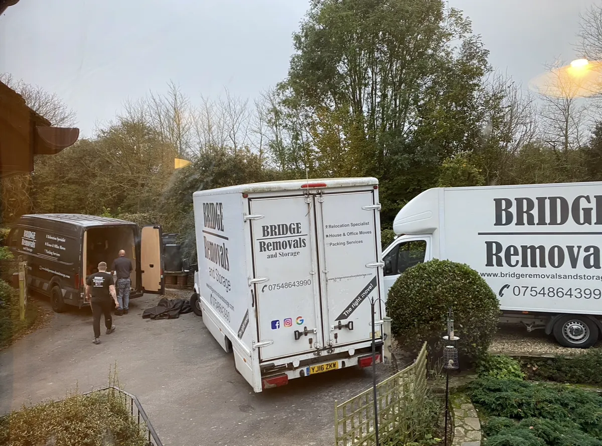 House Removals Viewed from an Upstairs Window Bridge Removals crew loading three vans for a house removals job, viewed from an upstairs window.