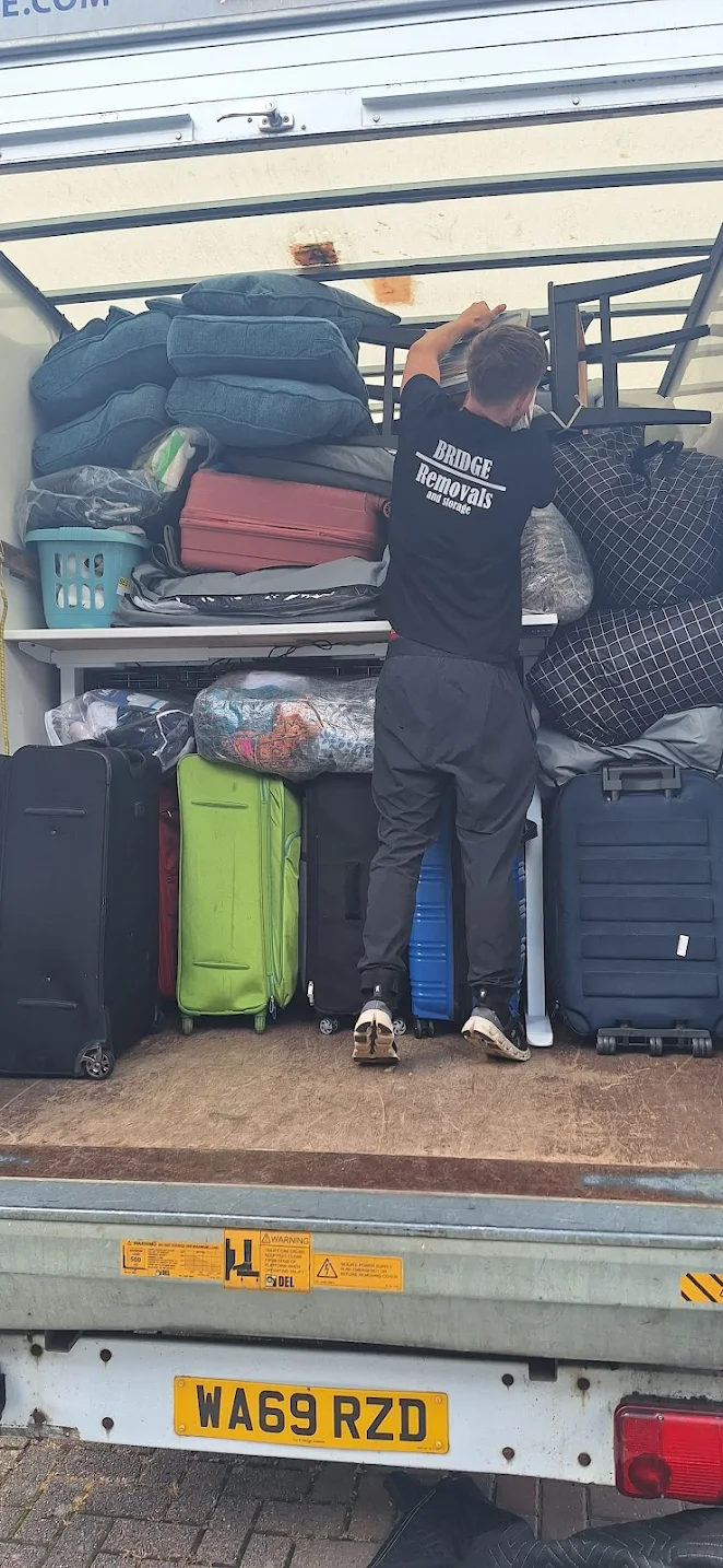 Customer-submitted photo showing a Bridge Removals crew member steadying furniture in a loaded van