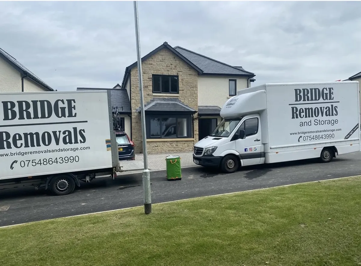 Matching Luton Vans At A New Build Two matching Bridge Removals Luton vans outside a new-build detached house on a house removals job.