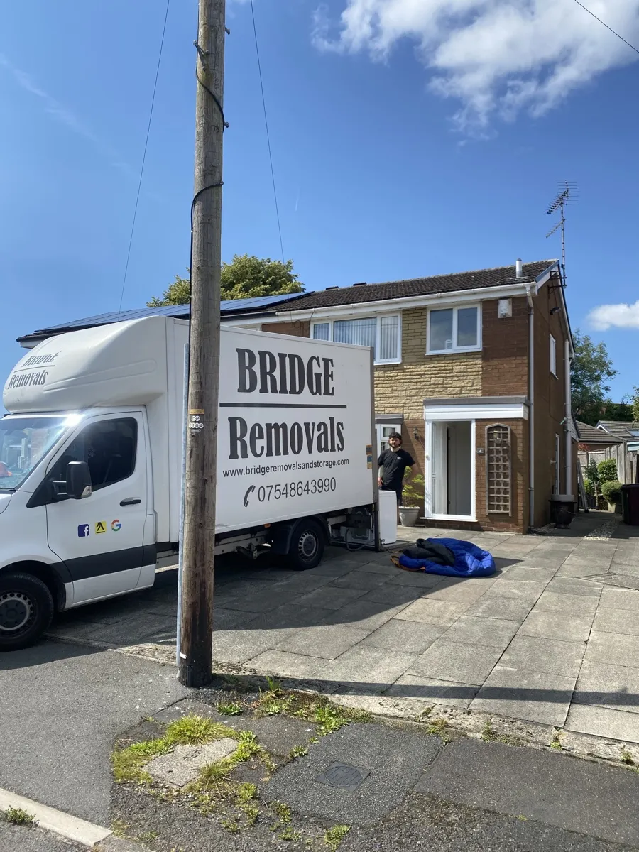 House Removals at a Manchester Semi-Detached House Bridge Removals van beside a telegraph pole outside a brick semi-detached house in Manchester, on a house removals job.